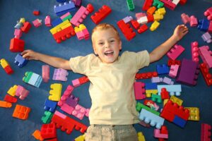 Young girl in child therapysmiling while surrounded by building blocks